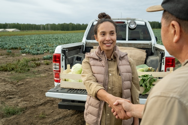 Photo happy businesswoman shaking hand of mature farmer