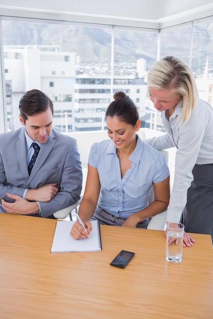 Happy businesswoman showing colleagues something on her notepad