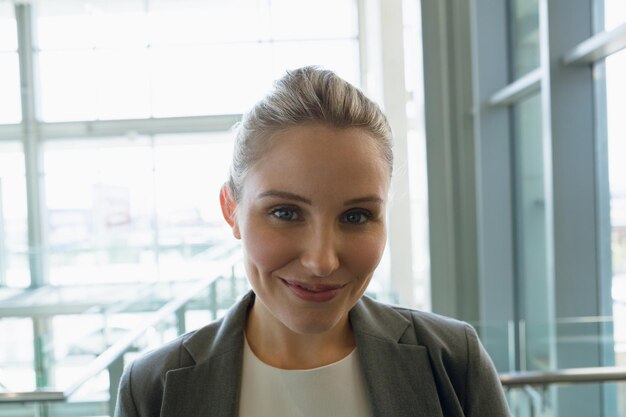 Photo happy businesswoman standing in the corridor at office