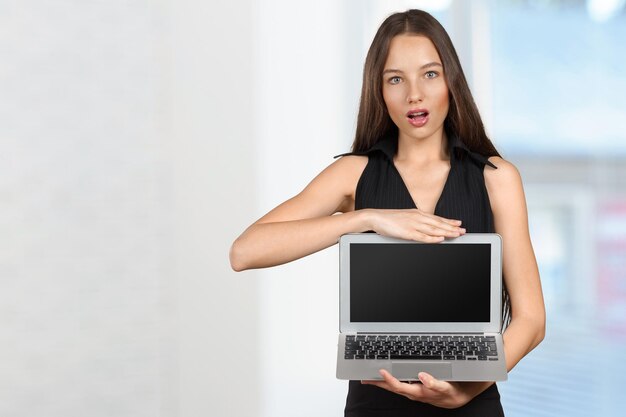 Happy businesswoman standing with laptop