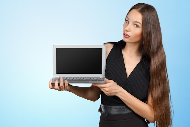 Happy businesswoman standing with laptop