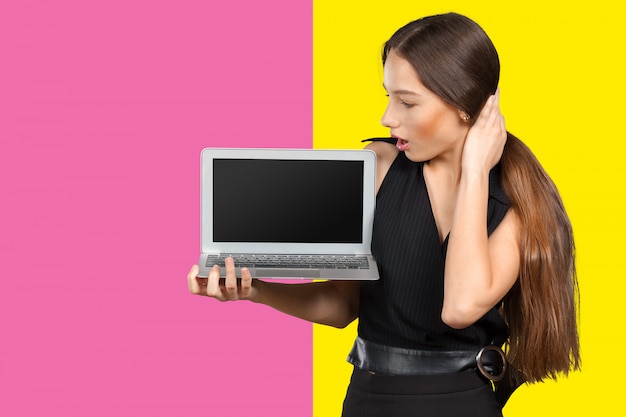 Happy businesswoman standing with laptop