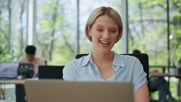 Happy businesswoman talking laptop video call coworking closeup woman speaking