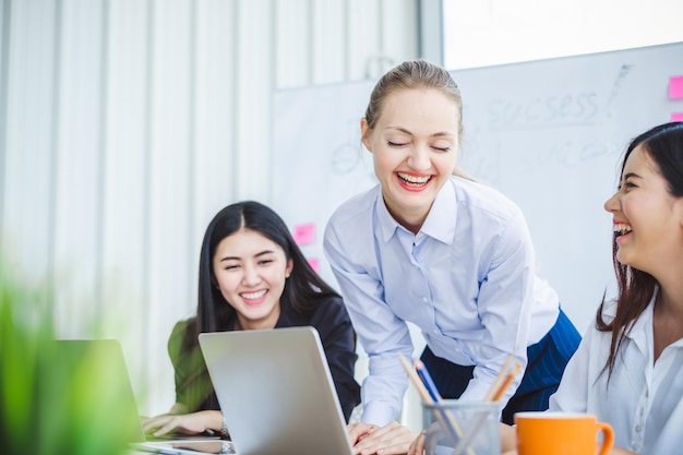 Happy businesswoman using laptops on office desk