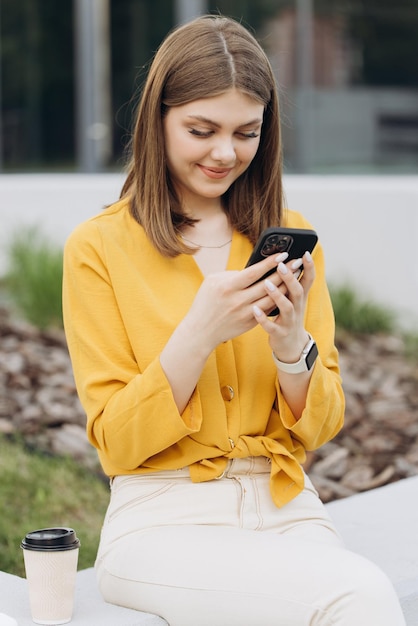 Happy businesswoman using mobile phone at remote workplace smiling woman browsing internet on smartp