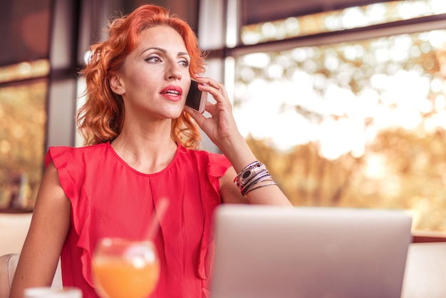 Happy businesswoman using tablet computer in a cafe