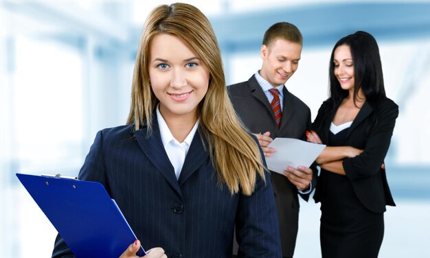 Happy businesswoman with colleagues in the background