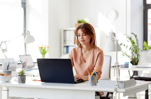 happy businesswoman with laptop working at office