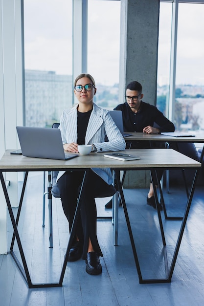 Happy businesswoman working on laptop Concept of business cooperation and teamwork Young people at the table in the office Modern successful people