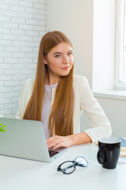 Happy businesswoman working on the laptop at office