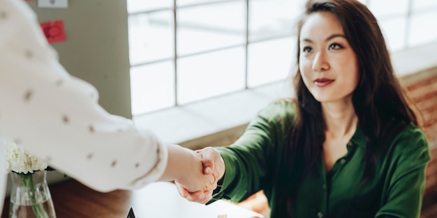 Donne di affari felici che fanno una stretta di mano