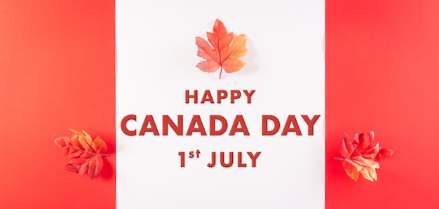 Happy Canada Day-concept gemaakt van rode zijden esdoornbladeren met de tekst op witte en rode achtergrond