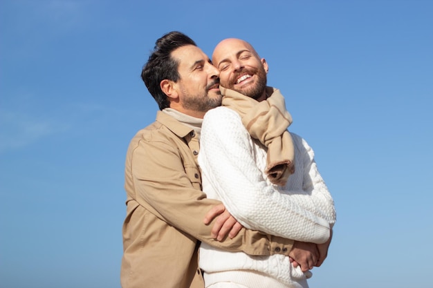 Felici gay spensierati che si abbracciano all'aperto