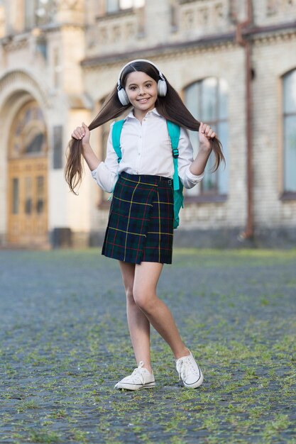 Happy carefree girl child back to school listening music, have fun concept.