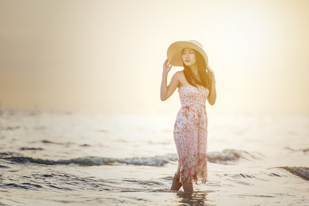 Счастливая беззаботная женщина, наслаждаясь красивый закат на пляже