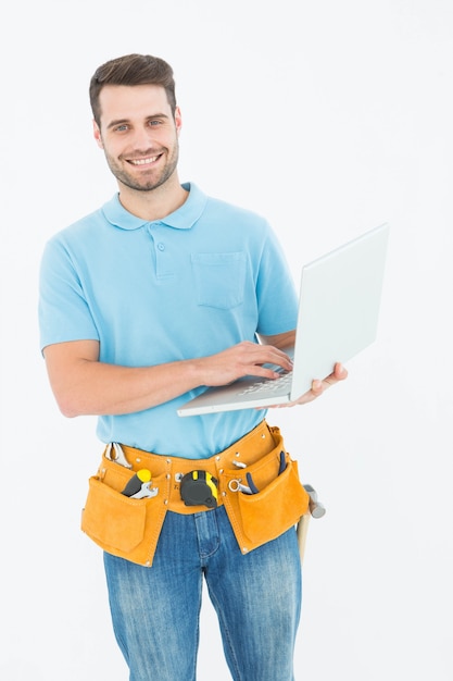 Happy carpenter holding laptop