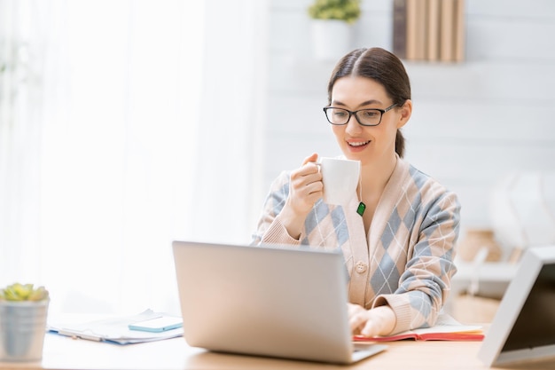 Happy casual beautiful woman working on a laptop at home.