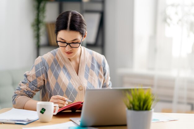 Happy casual beautiful woman working on a laptop at home.