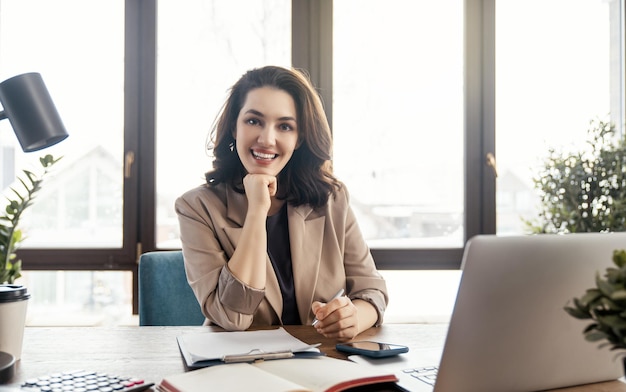 Happy casual beautiful woman working on a laptop in the office