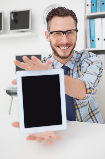 Happy casual businessman showing tablet pc 