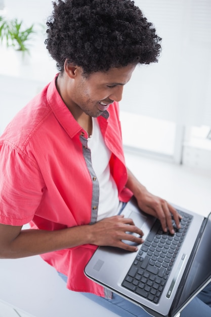 Happy casual businessman using laptop