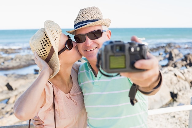 Photo happy casual couple taking a selfie by the coast