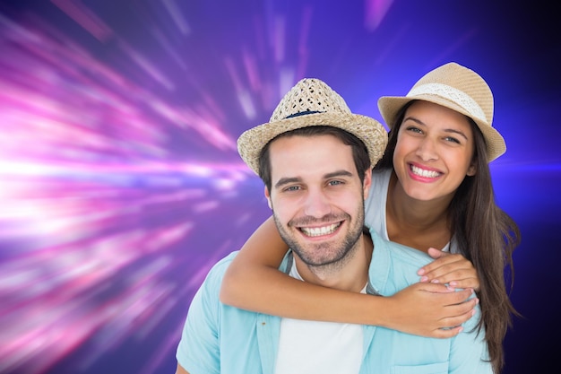 Happy casual man giving pretty girlfriend piggy back against valentines heart design