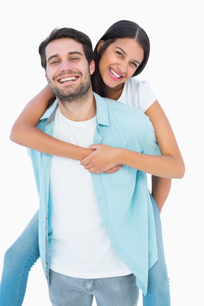 Happy casual man giving pretty girlfriend piggy back