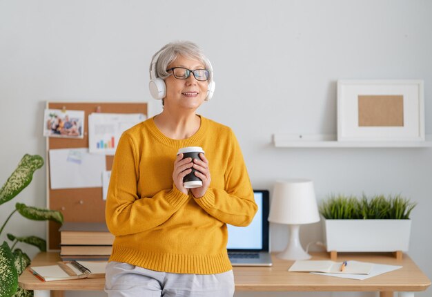 Happy casual senior woman working in home office.