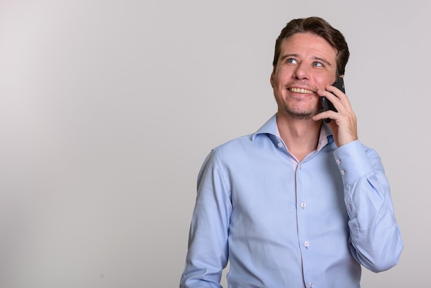 Happy Caucasian businessman talking on mobile phone