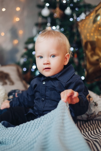 Happy caucasian child sits in christmas atmosphere and relaxes