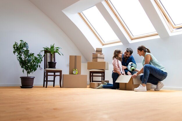 Happy caucasian family moving into new home and unpacking boxes together.