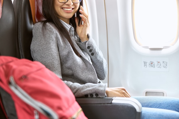 Happy caucasian female passenger in airplane salon before fly