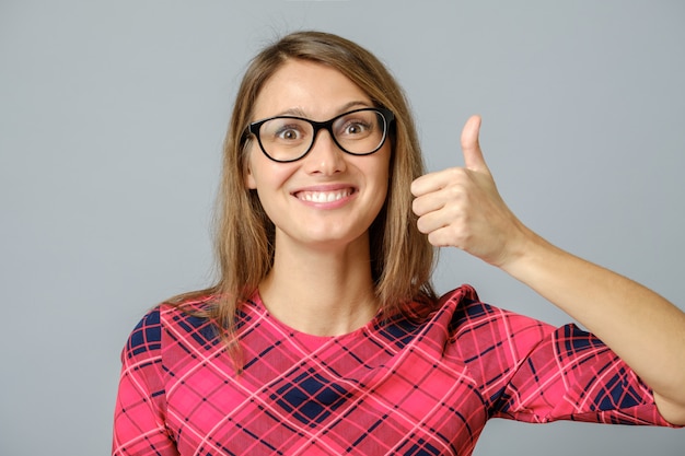 Photo happy caucasian female wearing red gress making thumb up sign