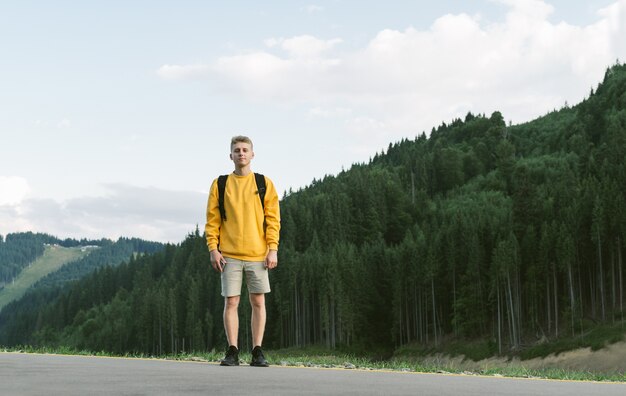 モミの森に立っている幸せな白人男性ハイカー観光客