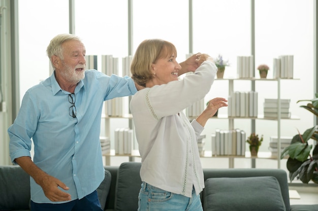 Happy Caucasian senior couple dancing at home