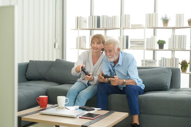 Happy caucasian senior couple playing games at home