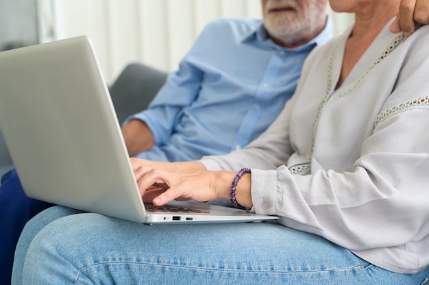 Happy Caucasian senior couple using laptop at home