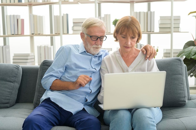 Happy Caucasian senior couple using laptop at home