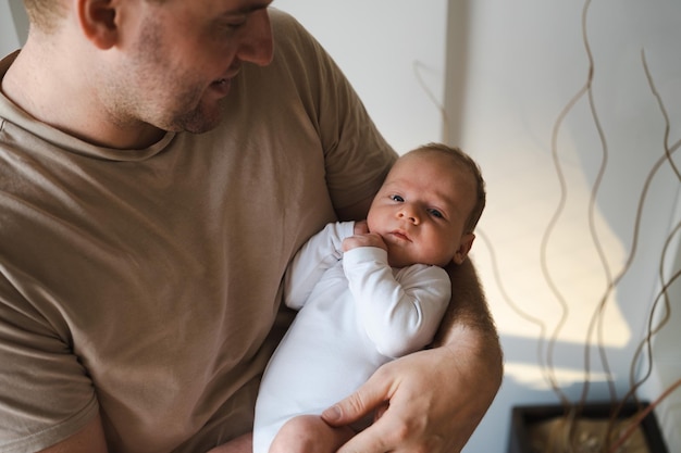 Happy caucasian thirty year old blond man holding newborn little baby father and child relationship