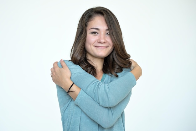 Happy caucasian woman hugging herself with natural emotional enjoying face