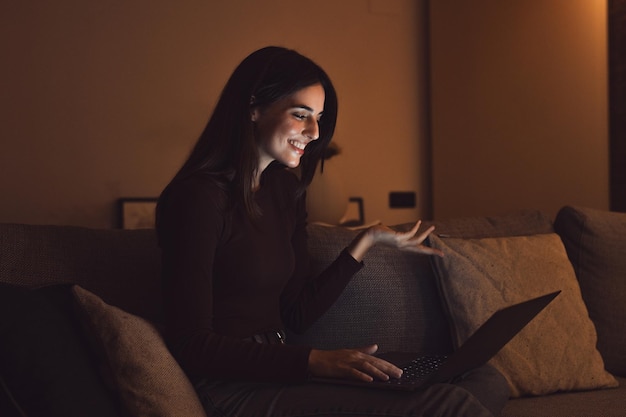 Фото Счастливая кавказская молодая студентка смотрит вебинар слушает онлайн-курс общается по видеоконференционному звонку изучает язык в приложении смеется учится с учителем урок смотрит на ноутбук ночью xa