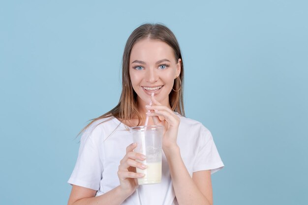 Happy caucasian young woman in summer casual light clothes with plastic glass