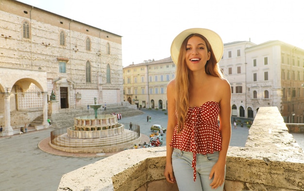 Фото Счастливая веселая модная девушка в италии. красивая женщина, посещающая старый средневековый город перуджа, италия.