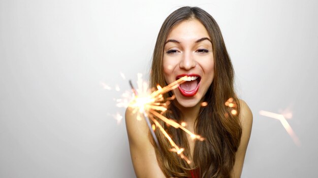 Photo happy cheerful girl holding bengal lights at party