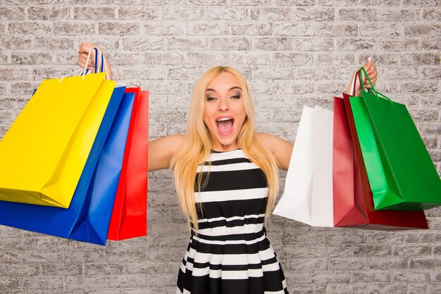 Happy cheerful girl holding pacs with new clothes