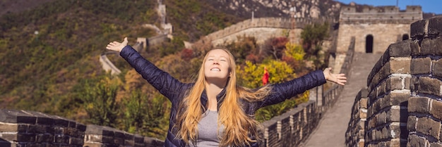 Happy cheerful joyful tourist woman at great wall of china having fun on travel smiling laughing and