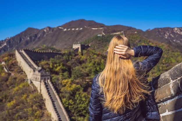 笑って笑って旅行を楽しんでいる中国の万里の長城で幸せな陽気な楽しい観光客の女性