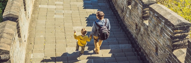 Happy cheerful joyful tourists dad and son at great wall of china having fun on travel smiling