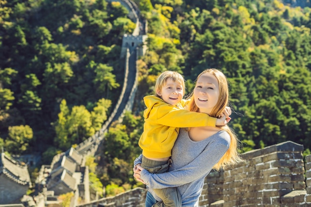Happy cheerful joyful tourists mom and son at great wall of china having fun on travel smiling
